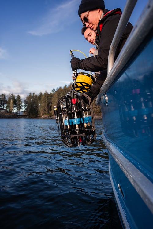 Ascension depth sampler is lowered into the water from the side of a boat. View is from beside the boat up close