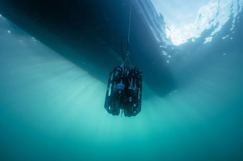 Ascension eDNA depth sampler under a boat haul below the surface of the water with the sun shining through the water