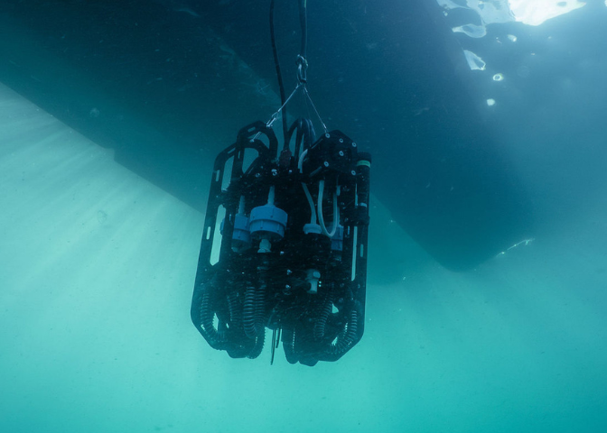 View of the Ascension depth sampler from below as it is lowered into the ocean from a small boat View of the Ascension depth sampler from below as it is lowered into the ocean from a small boat