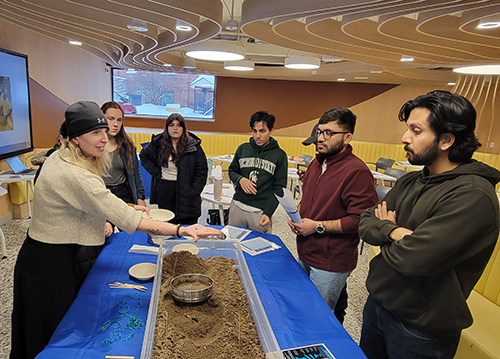 A instructor teaches university students about microplastic pollution in a classroom