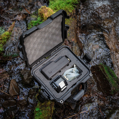 eDNA sampler in its box on a log in a creek