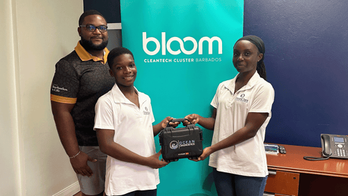 Mr. Damien Prescod of Export Barbados' Bloom program stands beside two students holding the Saturna Imaging System