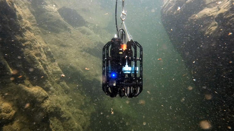 Underwater shot of the 22-pound automated sampling device with a light flashing to indicate that the instrument has begun sampling