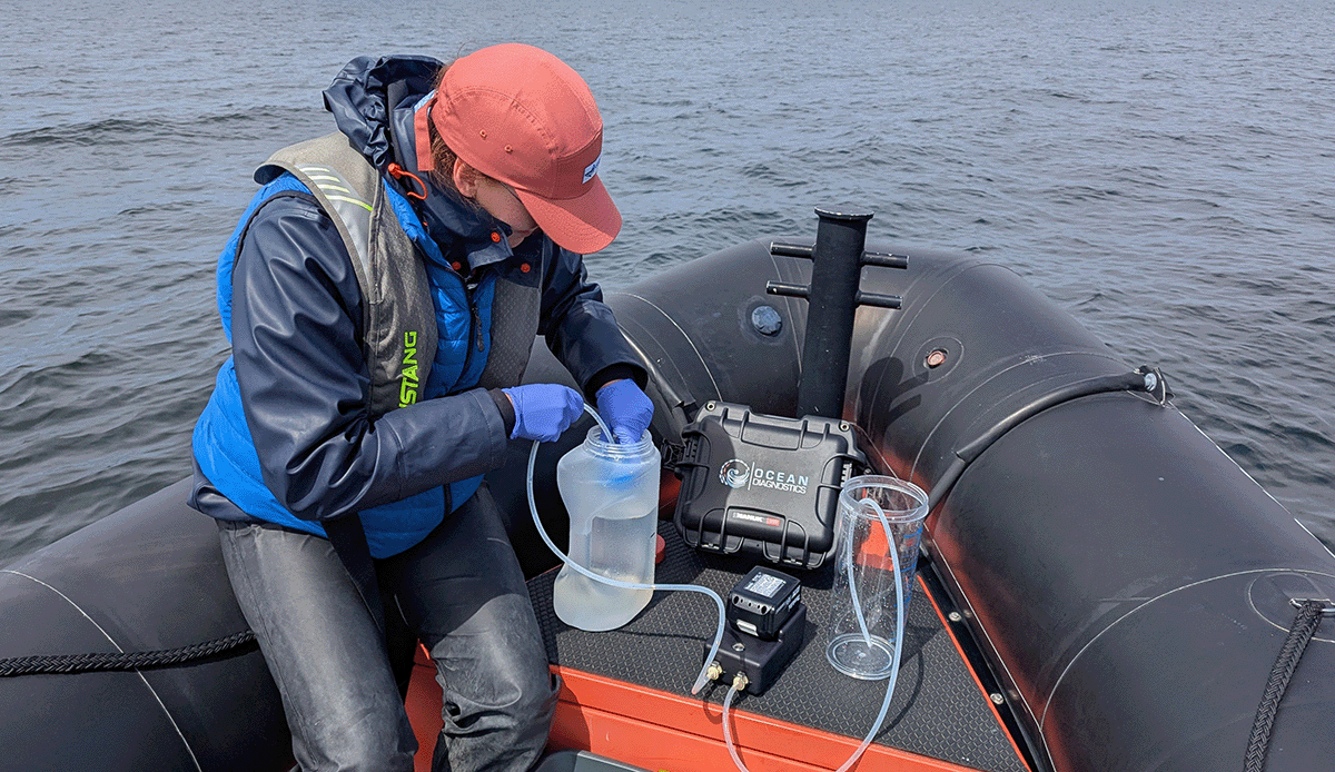 Researchers filters eDNA at the front of a zodiac using the eDNA surface sampler