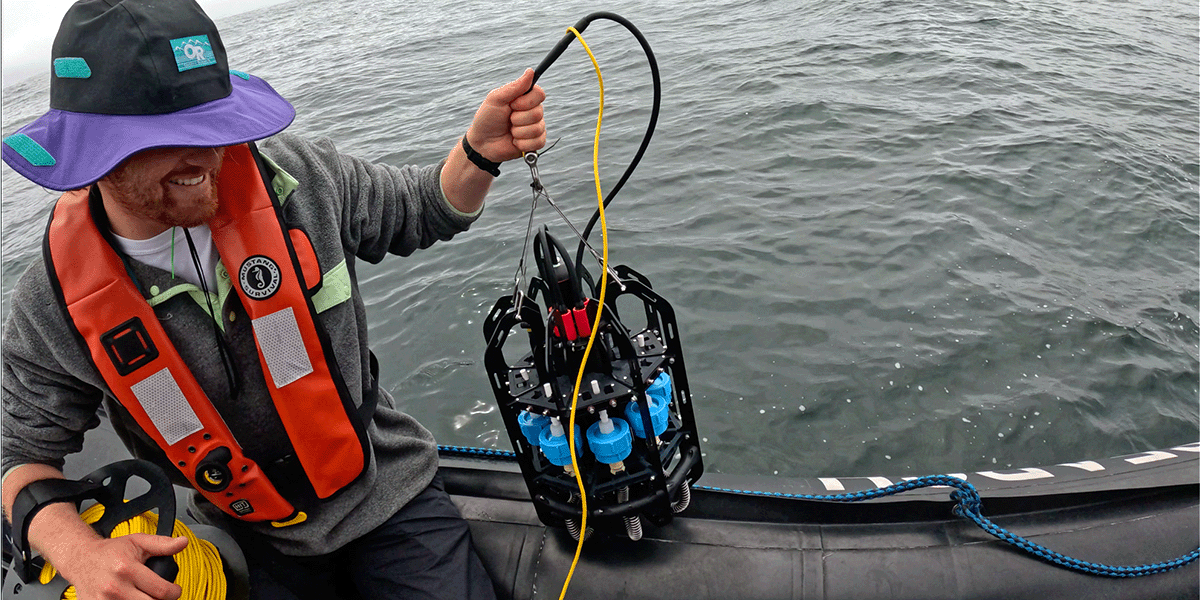 A university scientist holds Ascension on the side of a dinghy on the ocean